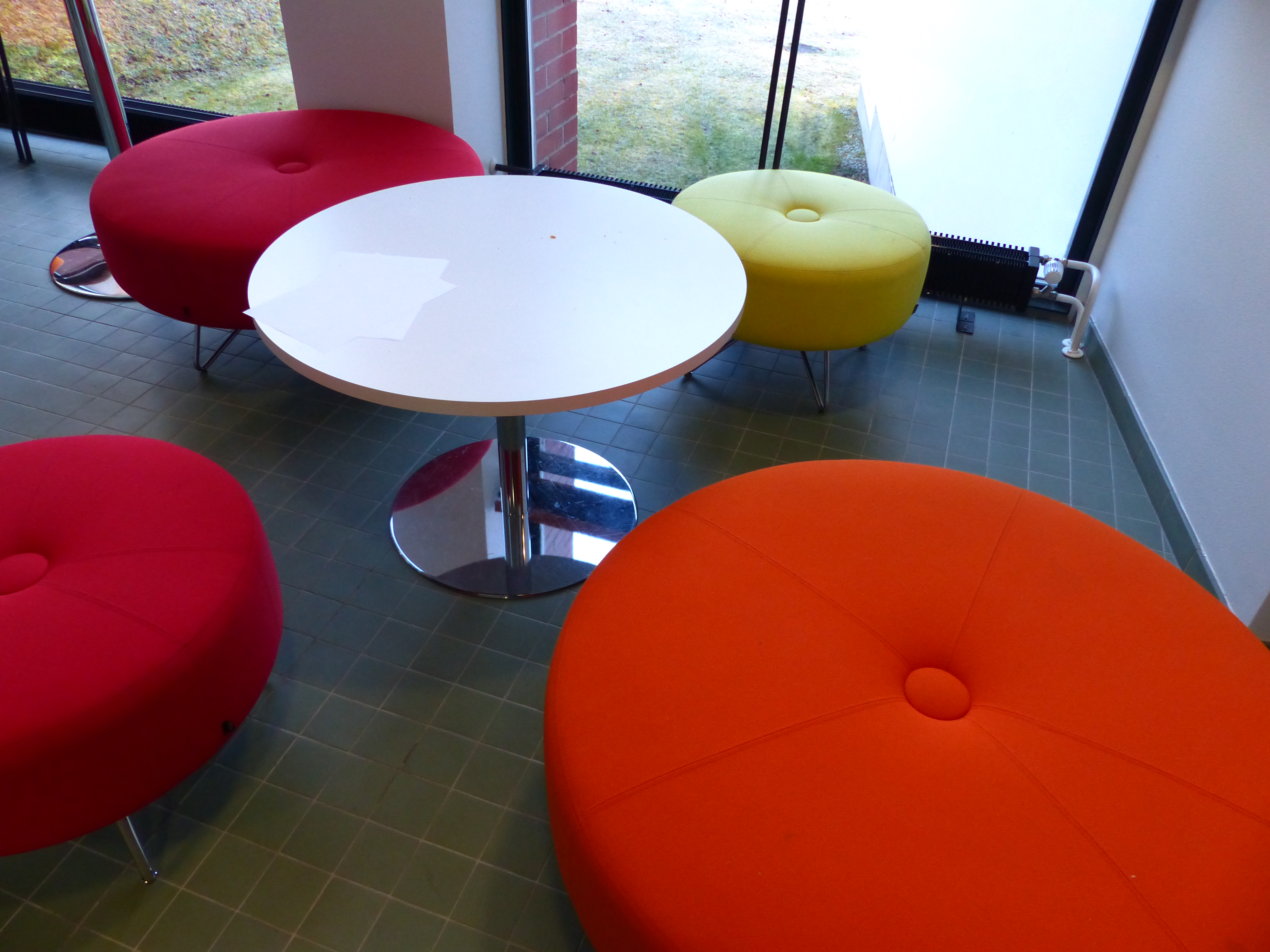 Pyöreitä tuoleja joiden keskellä pyöreä pöytä