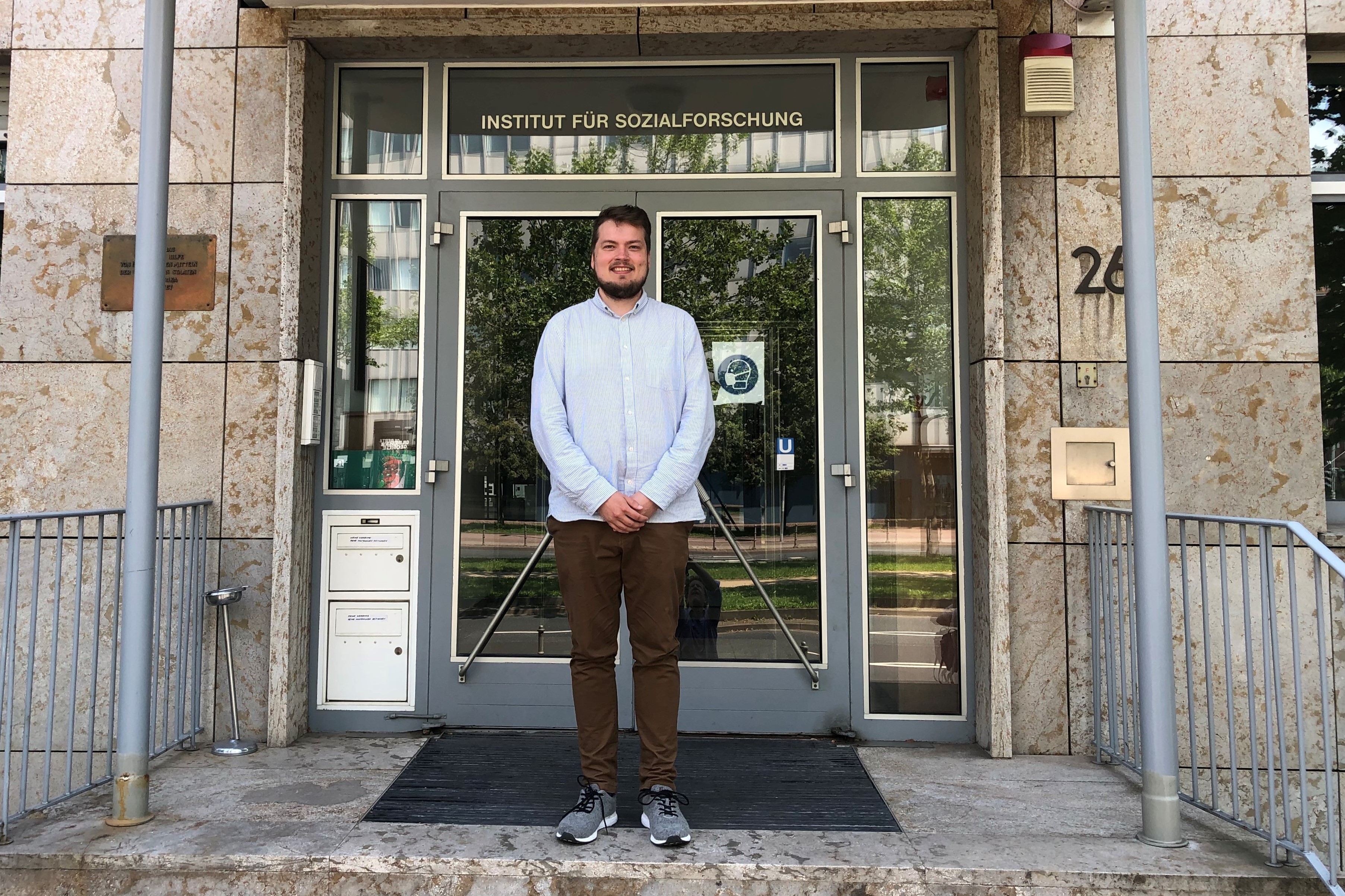 Vaasan yliopistossa väittelevä Jari Autioniemi Frankfurtin koulukunnan perustaman yhteiskuntatieteellisen tutkimuslaitoksen edessä Saksassa. Väitöskirjassa on sovellettu koulukunnan tunnetun edustajan Jürgen Habermasin kommunikatiivista toimintateoriaa. Kuva: Jari Autioniemen arkisto