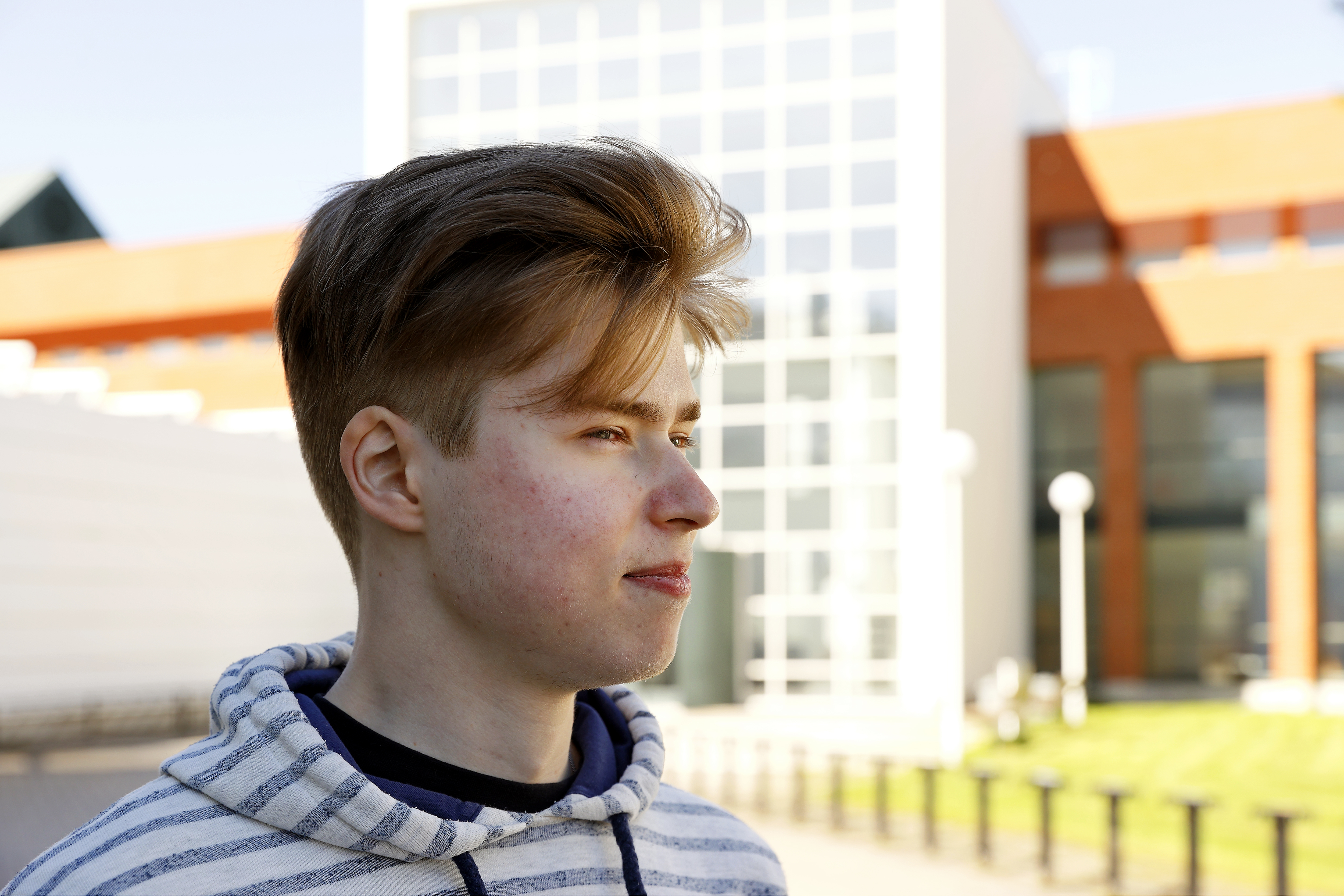 Poika seisoo kirjaston edessä
