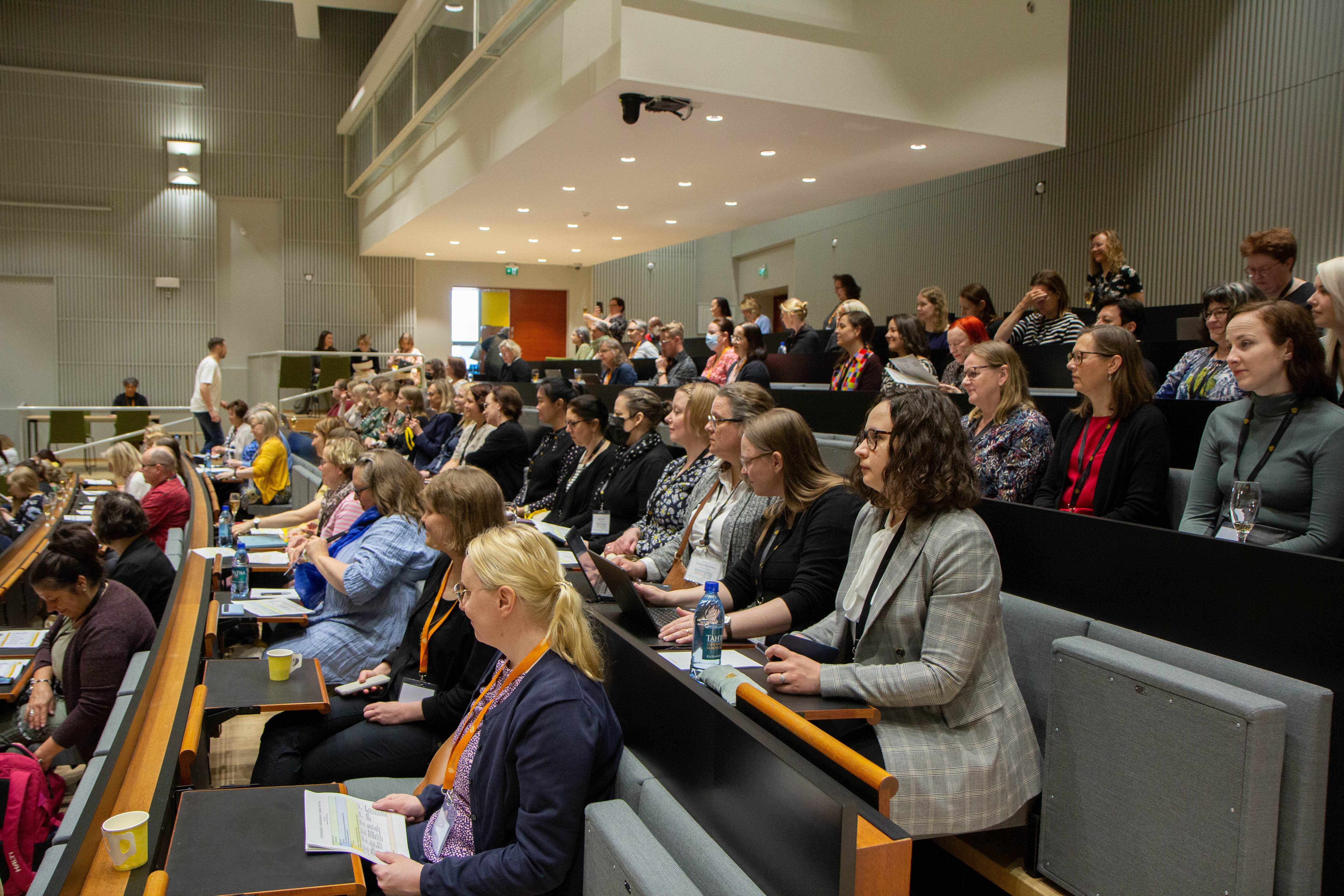Ihmisiä auditoriossa.