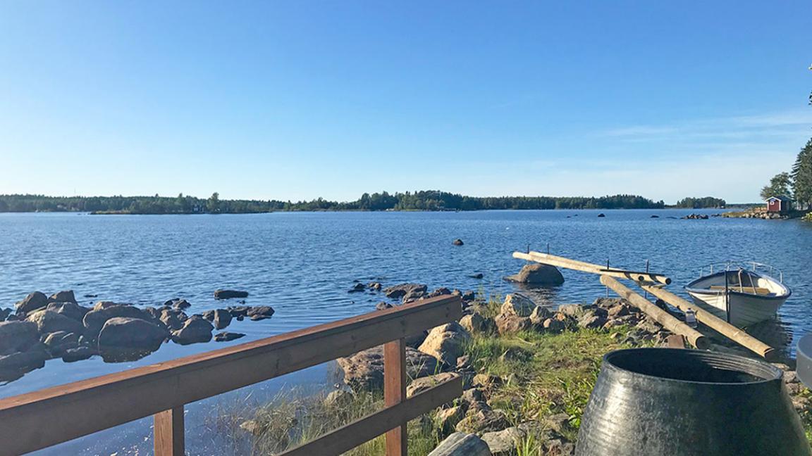Saaristomaisema, kuvattu kesämökin rannalta jossa vene ja laituri 