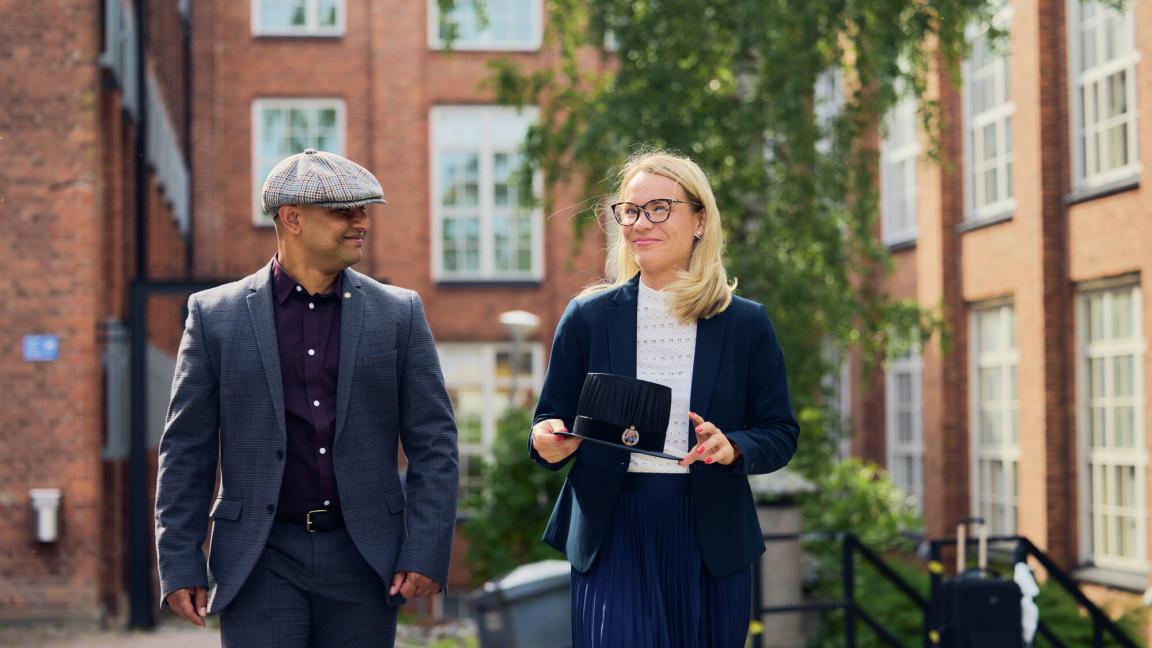 Nainen ja mies kävelemässä Vaasan yliopiston kampuksella 