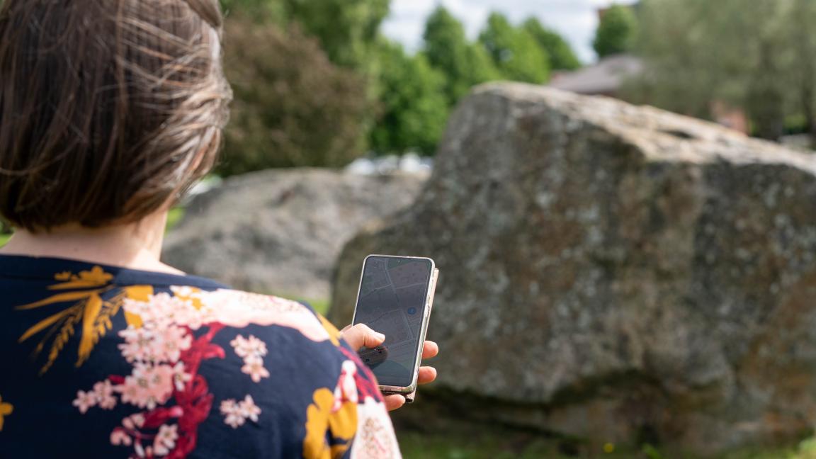 Nainen puhelimen kanssa pelaamassa