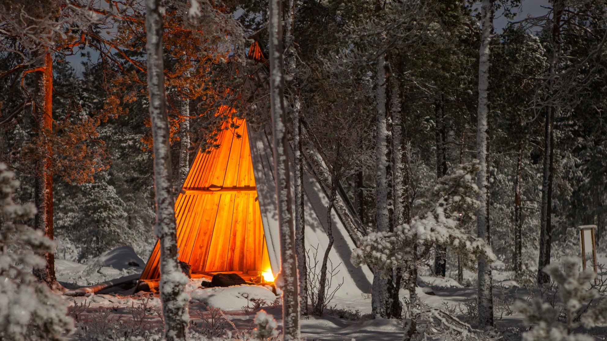 Nuotio ja laavu lumisessa maisemassa