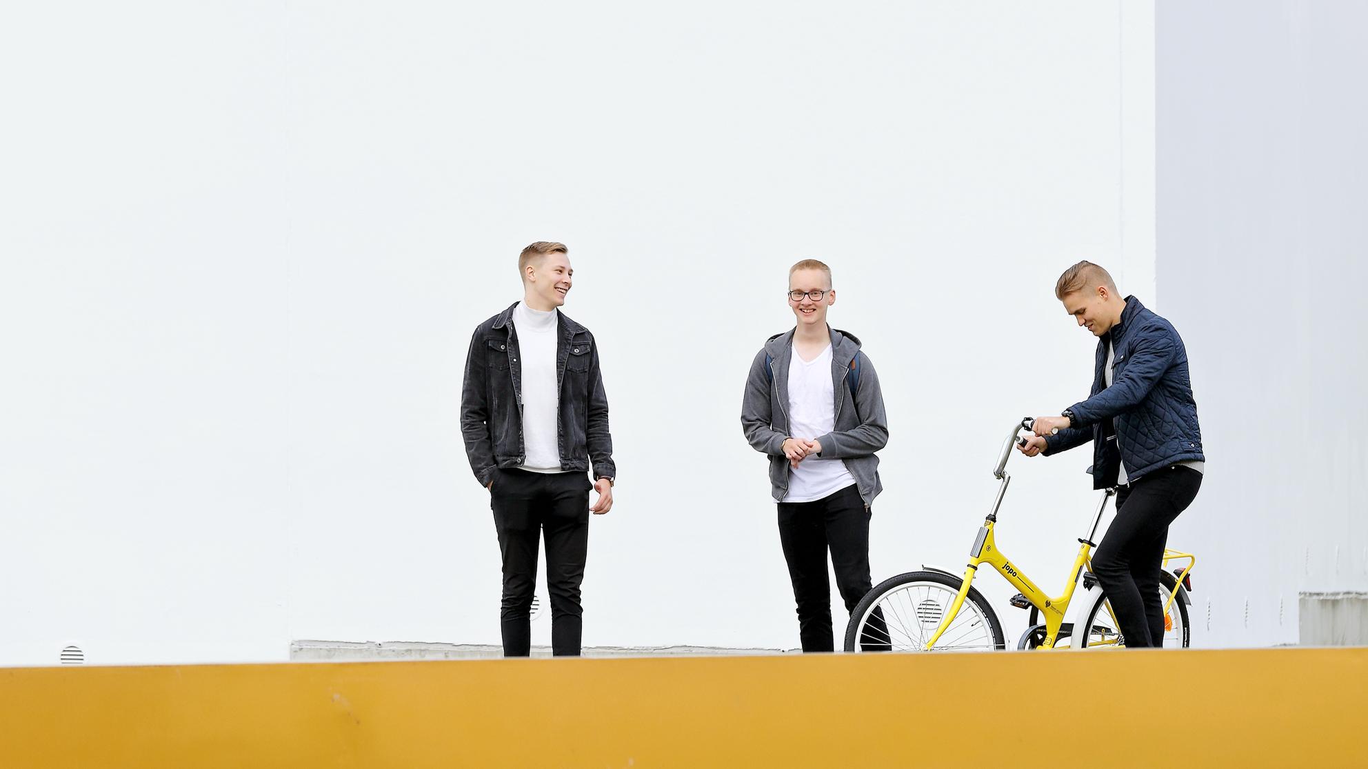 Kolme opiskelijaa kampuksella.