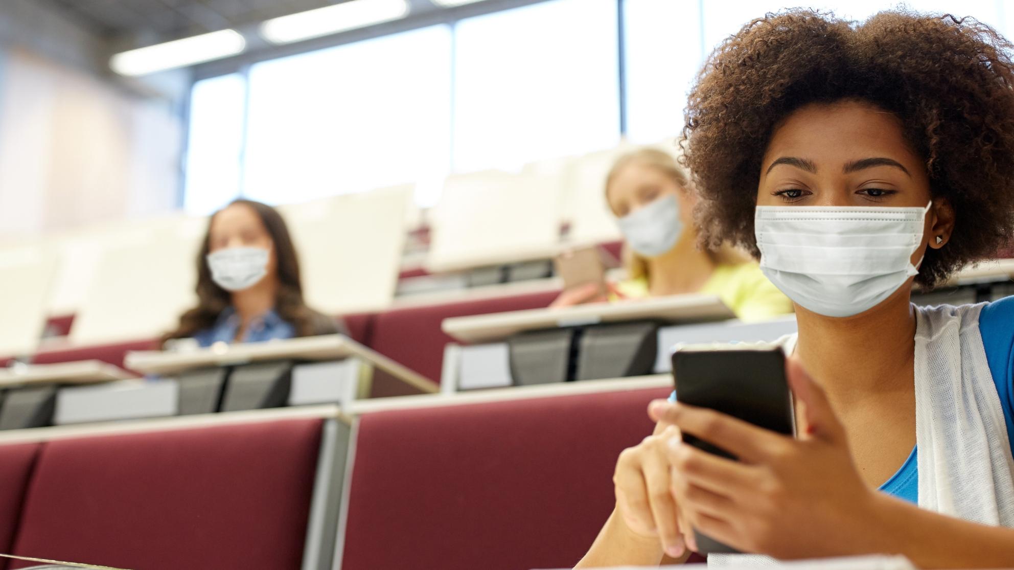 Nainen luennolla maski kasvoilla. 