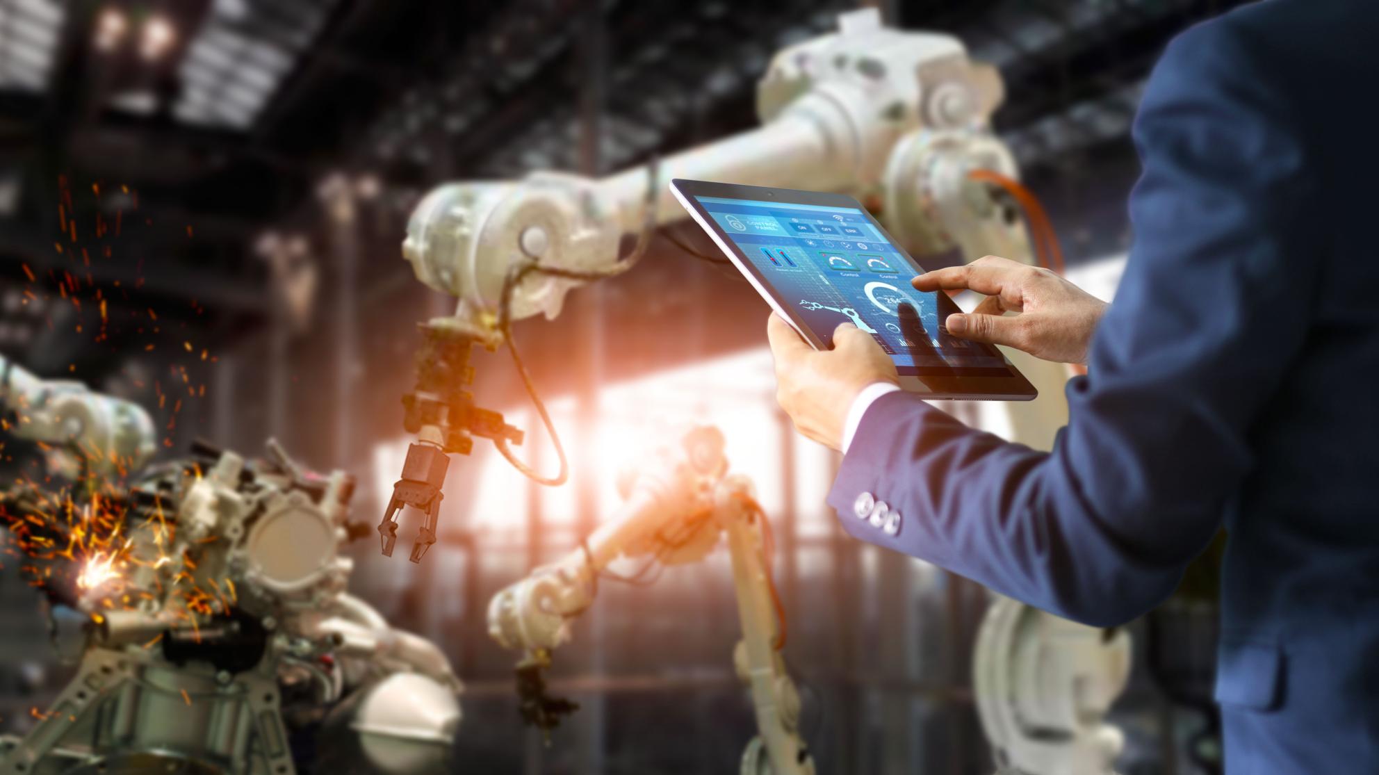 Mies tabletin kanssa tehdasmiljöössä