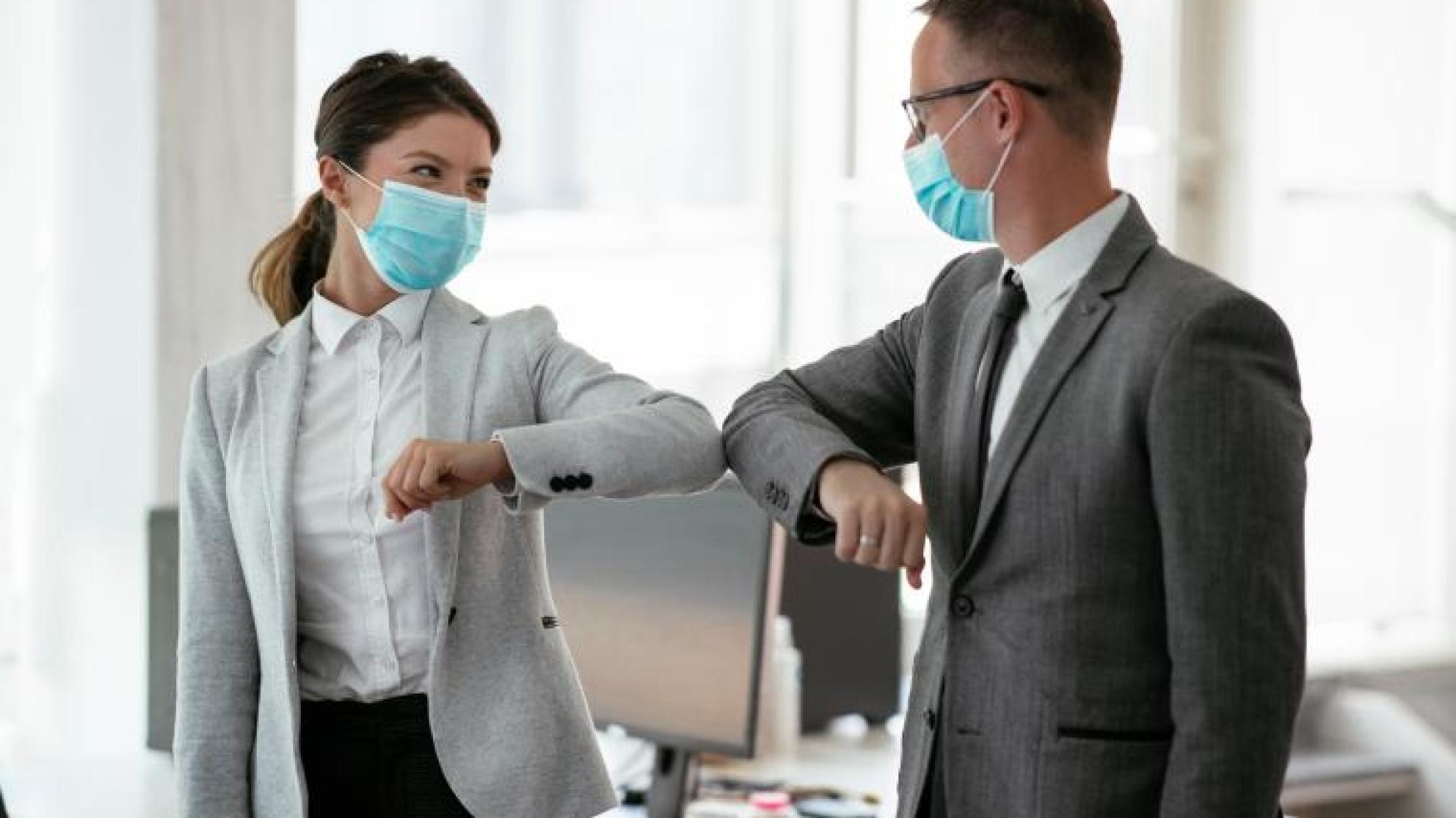 Ihmiset tervehtivät toisiaan maskit kasvoilla