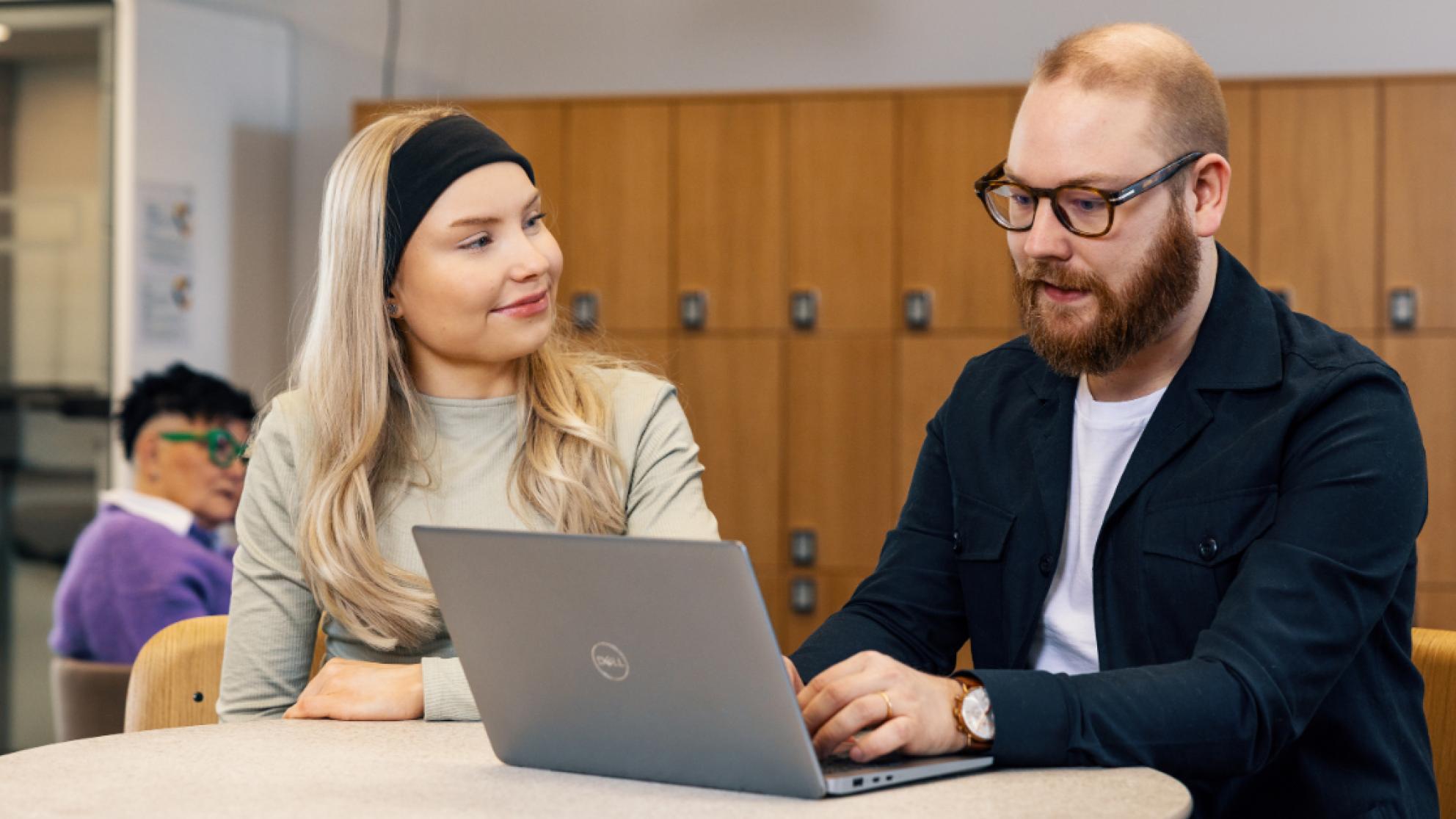 Kaksi opiskelijaa työskentee yhdessä läppärin äärellä