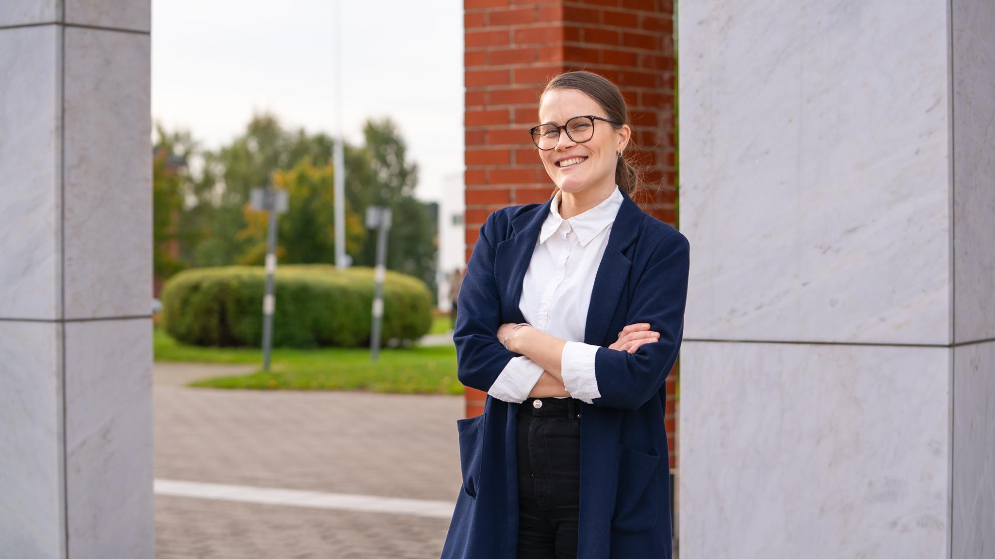 Essi Vesterinen Vaasan yliopiston kampuksella marmoriportin ääressä