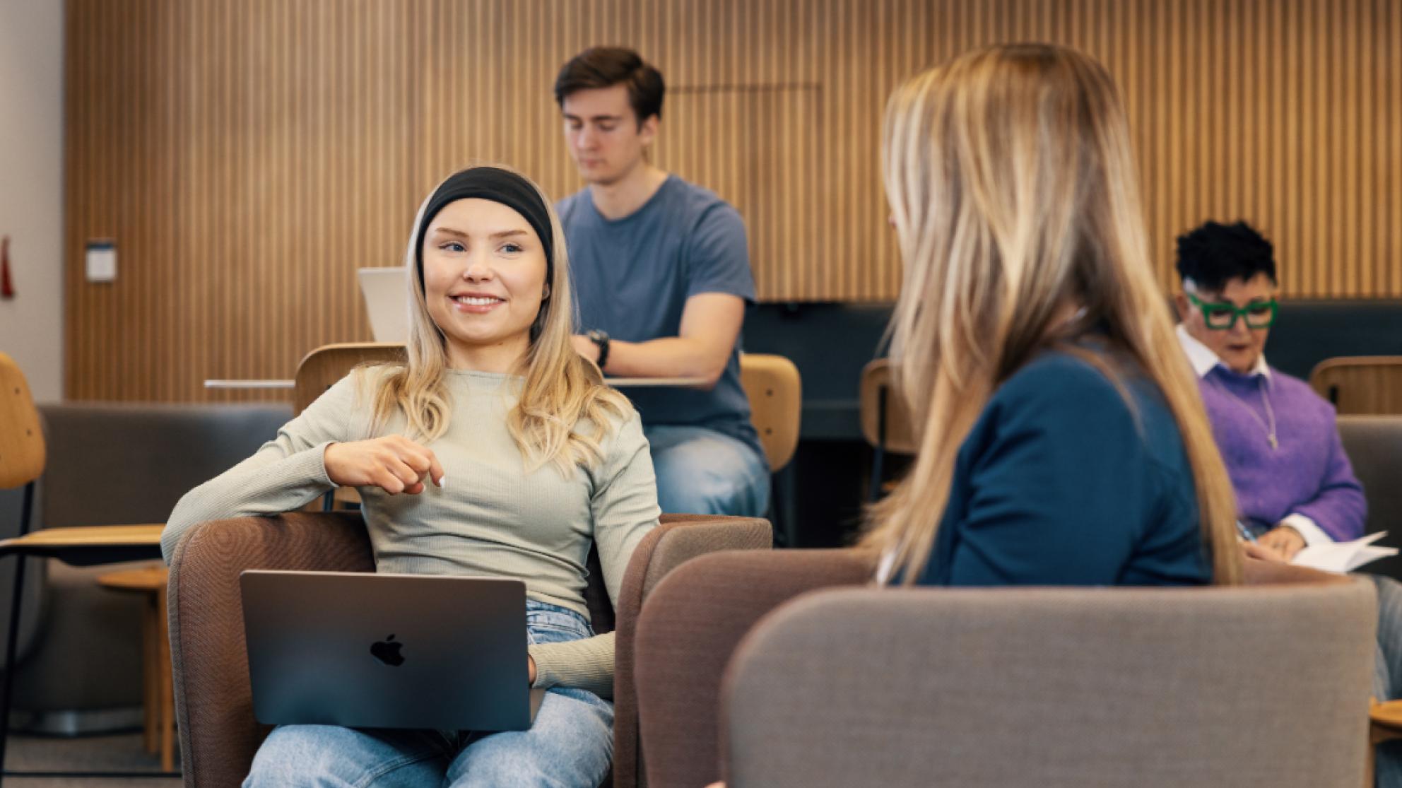 Opiskelijat keskustelevat pöydän ääressä