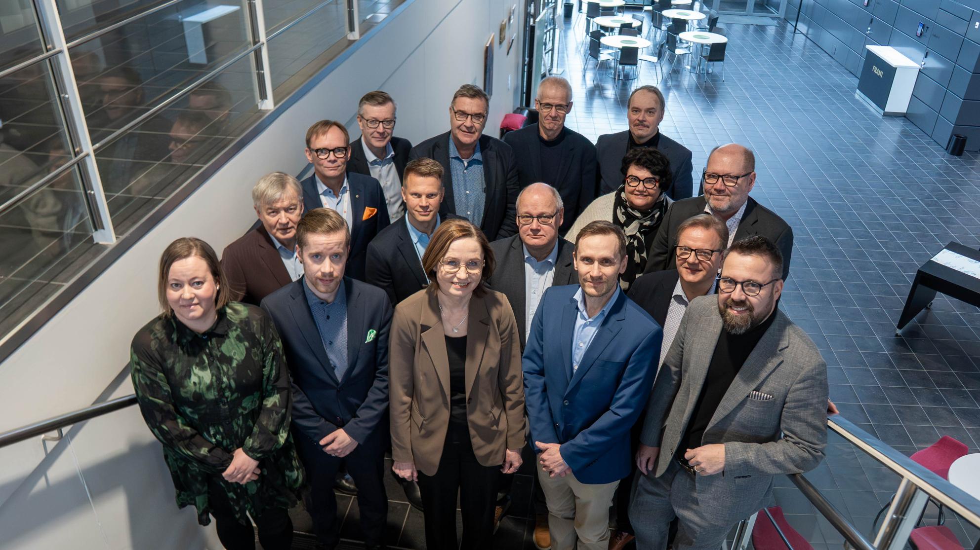 Joukko ihmisiä poseeraa portaikossa