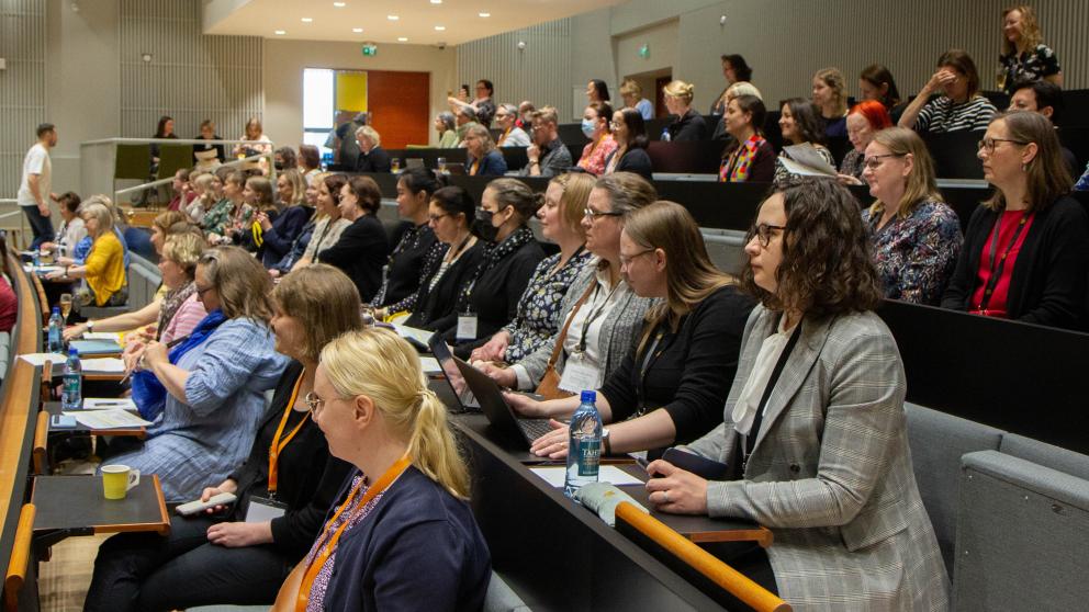 Ihmisiä auditoriossa.