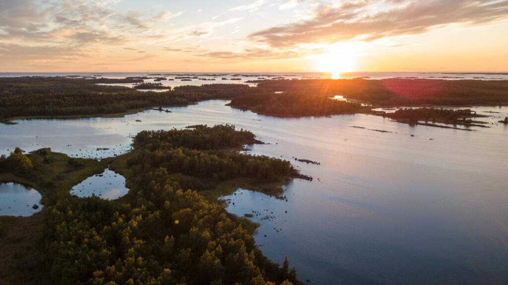 Aerial view of Finnish archipelago with the sun setting in the horizon