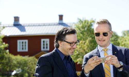 kaksi henkilöä katsovat puhelimen näytöltä jotain. 