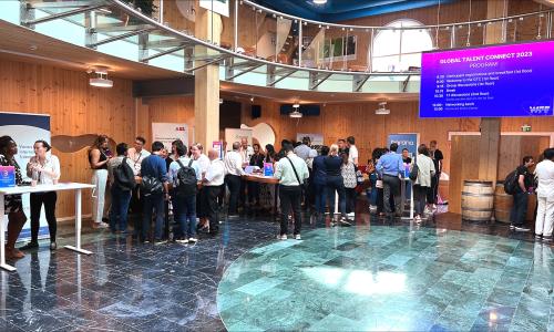 A group of people gathered in the lobby around presentation desks.