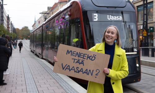 Tyttö raitiovaunun vierellä