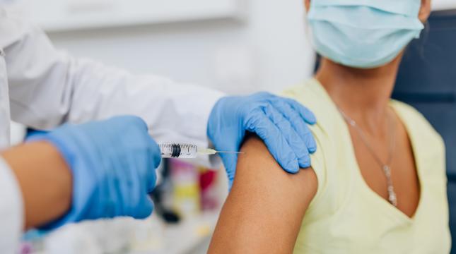 Lääkäri antaa rokotteen naiselle