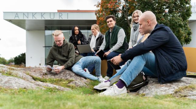 Kuvassa opiskelijoita kampuksella ulkona juttelemassa ja istuskelemassa. 