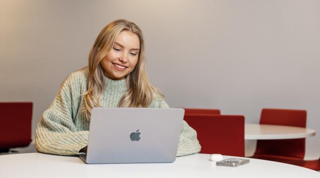 Kuvassa opiskelija läppärin kanssa