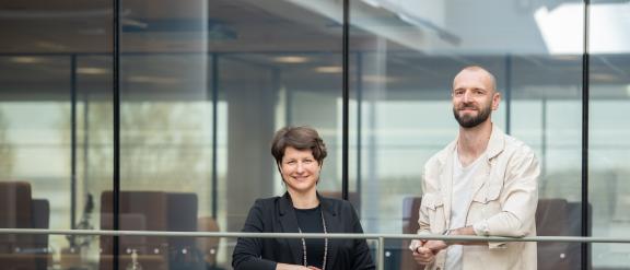 Kuvassa hymyilevät nainen ja mies Vaasan yliopiston tiloissa