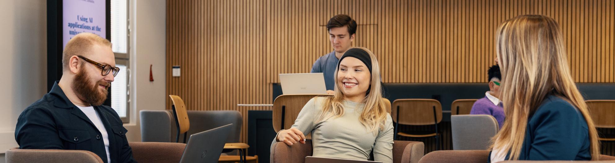 Opiskelijat työskentelevät aulatilassa
