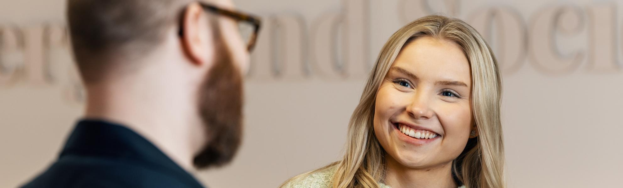 Tyttö ja poika keskustelevat hymyillen