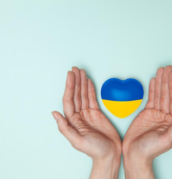 Ukrainan väreissä oleva sydän henkilön käsien välissä