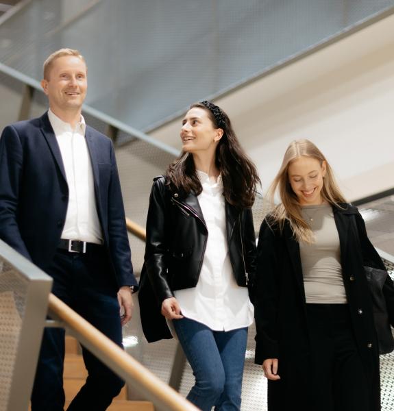 Opettaja ja opiskelijat kävelevät rappusia alas