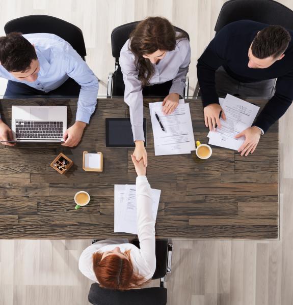 A handshake between employer and new employee over a table. 