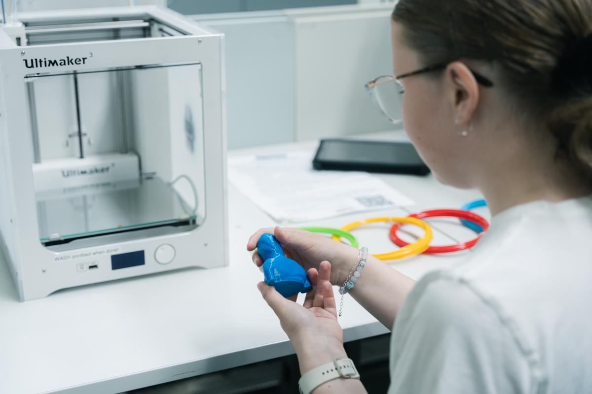 Nuori tutkimassa 3D-tulostettua esinettä