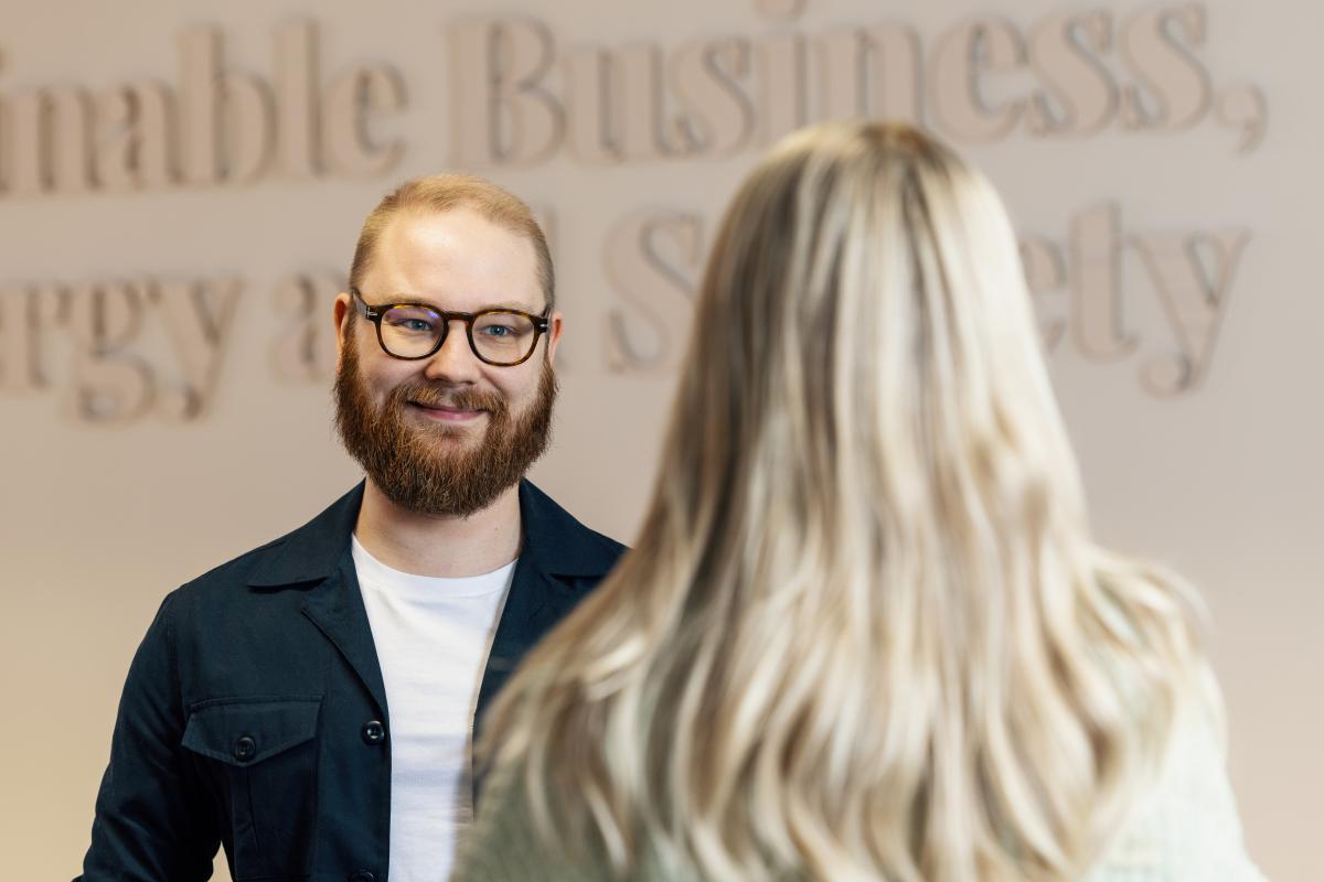 Mies hymyilee kuvassa vaaleahiuksiselle tytölle