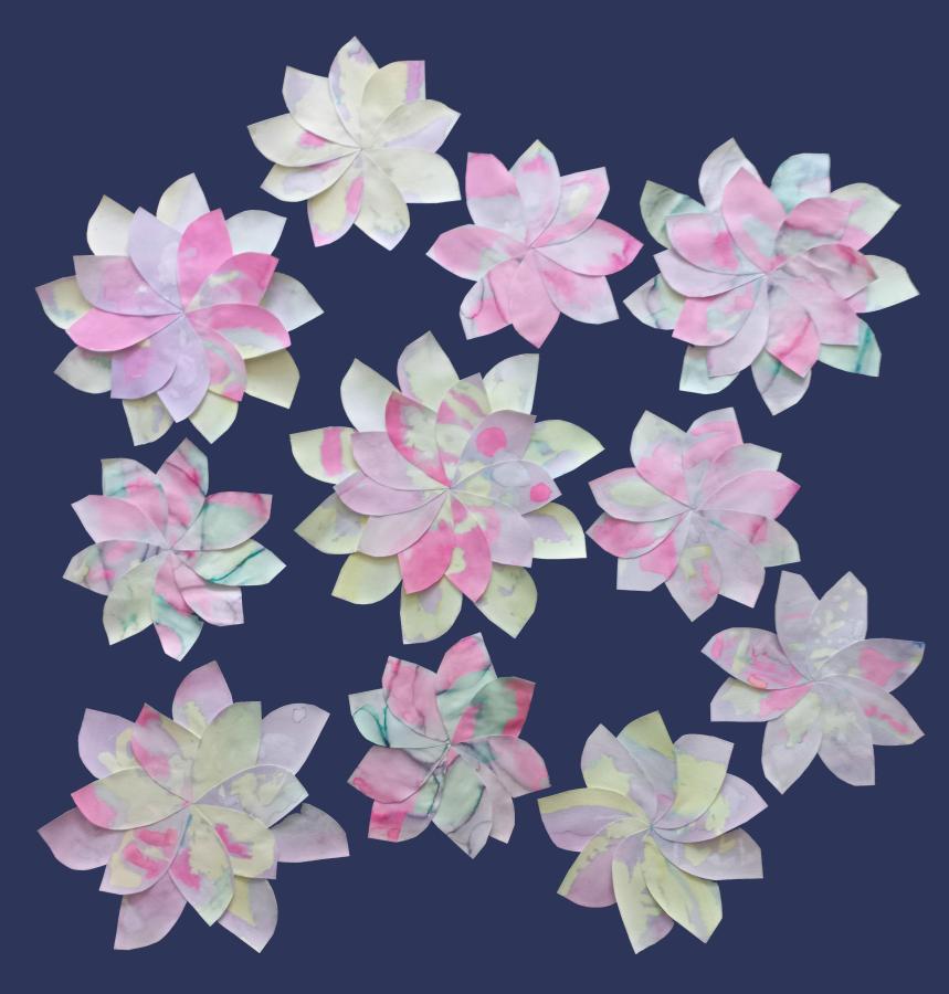 Punakaalikemiaa. Lasten punakaalikemialla maalaamista terälehdistä on askarreltu erikokoisia kukkia.