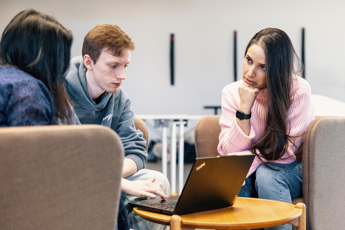 Opiskelijaryhmä keskustelee pöydän ääressä