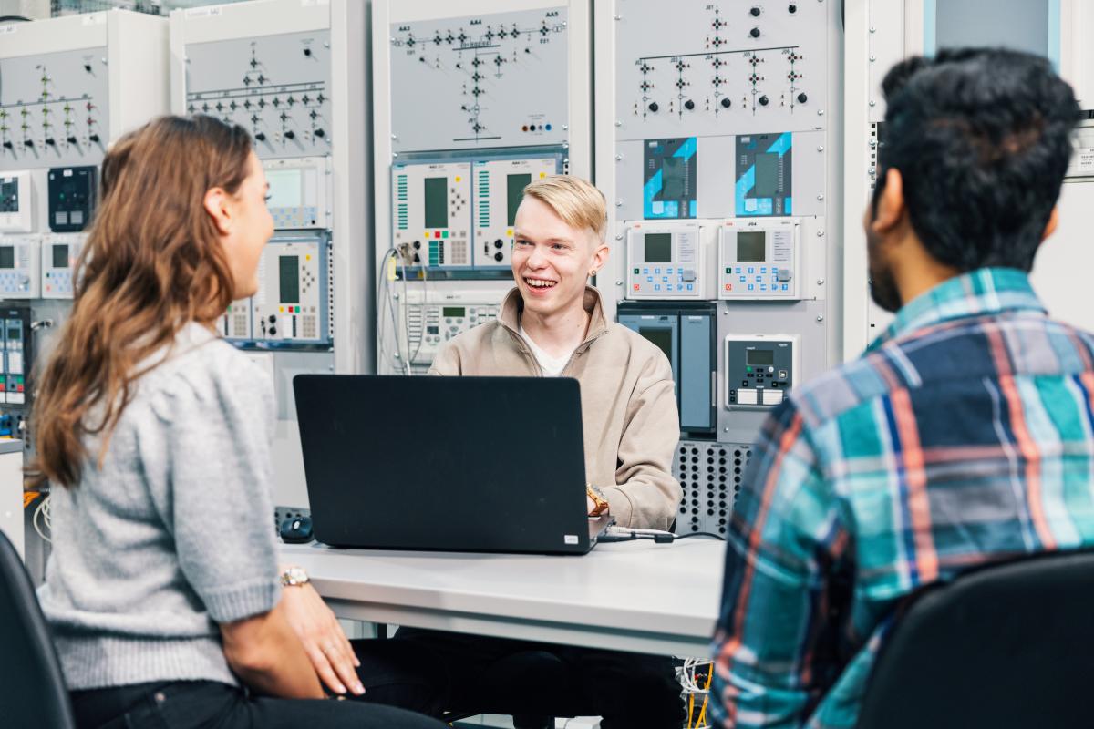 Opiskelijaryhmä istuu pöydän ääressä tekniikan laboratoriossa