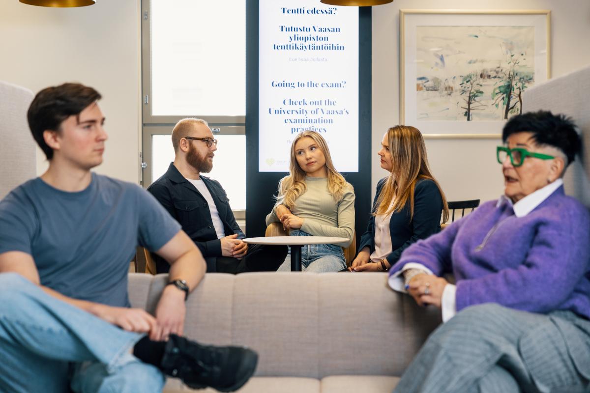 Opiskelijajoukko on kerääntynyt sohville keskustelemaan