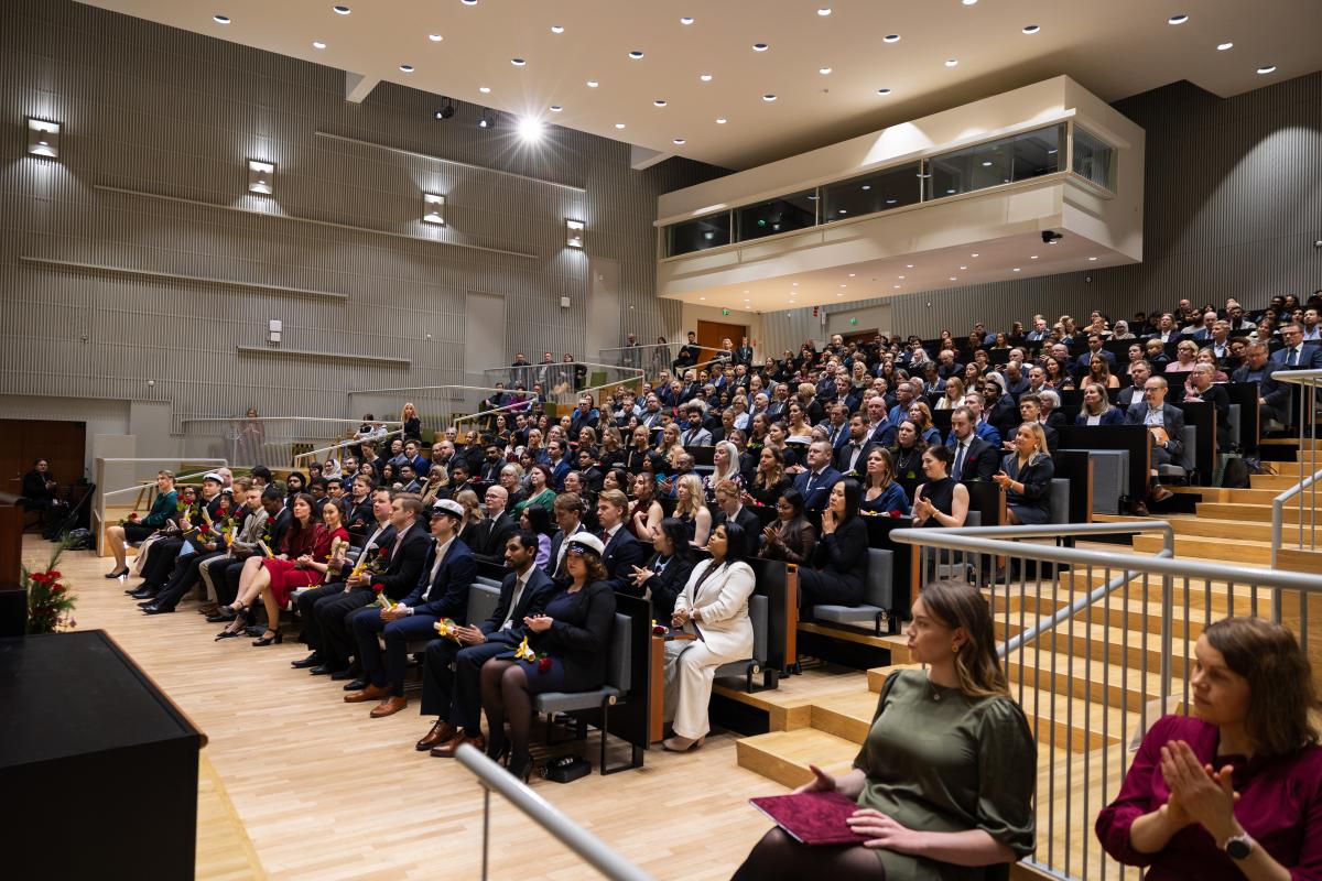 Auditorio täynnä valmistuneita sekä heidän läheisiään.