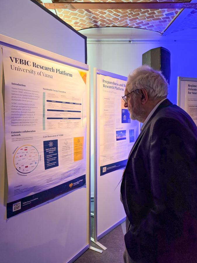 Kreikkalainen professori tutustuu tutkimusalustan julisteeseen