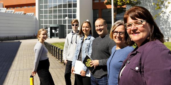 Opiskelijoita ja henkilökuntaa kampuksella