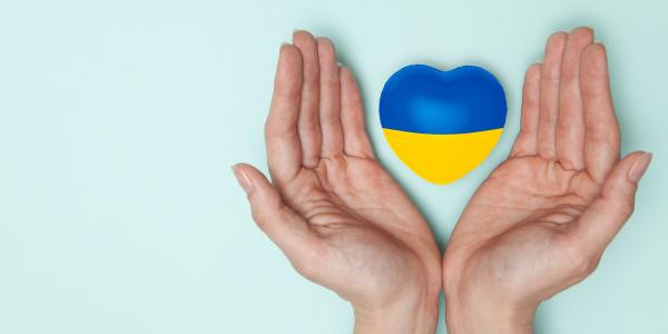 Kädet pitävät Ukrainan väreissä olevaa sydäntä