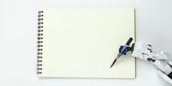 A robot hand is holding a pencil over a blank notebook