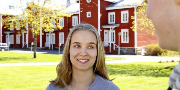 Tyttö hymyilee kampuksella
