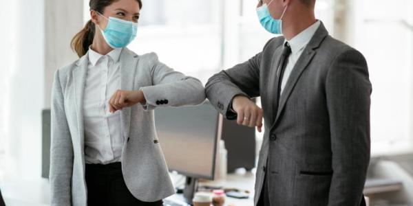 Ihmiset tervehtivät toisiaan maskit kasvoilla