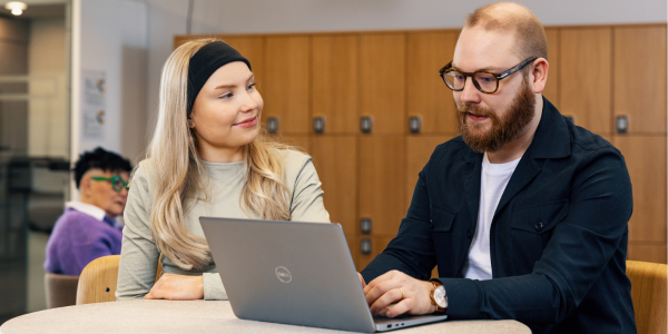 Kaksi opiskelijaa työskentee yhdessä läppärin äärellä