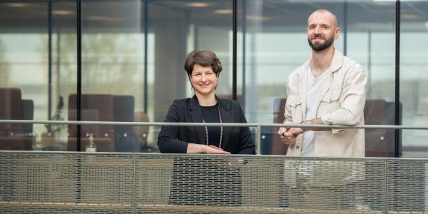 Kuvassa hymyilevät nainen ja mies Vaasan yliopiston tiloissa