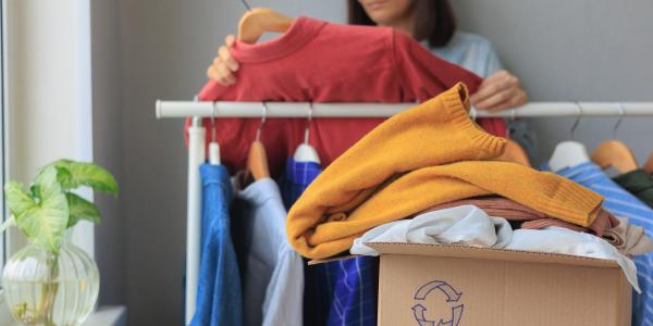 Nainen lajittelemassa vaatteita kierrätykseen