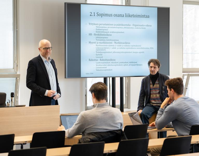 Opettajat luennolla opiskelijoiden kanssa
