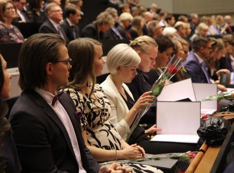 Paljon ihmisiä istuu isossa auditoriossa