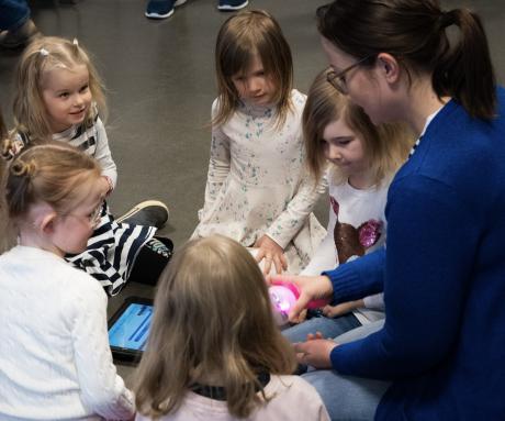Opettaja ja lapsia tutustumassa robottipalloon