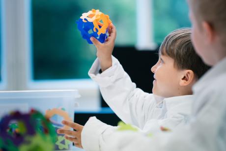 Kaksi poikaa katsoo itsphunista rakennettua palloa